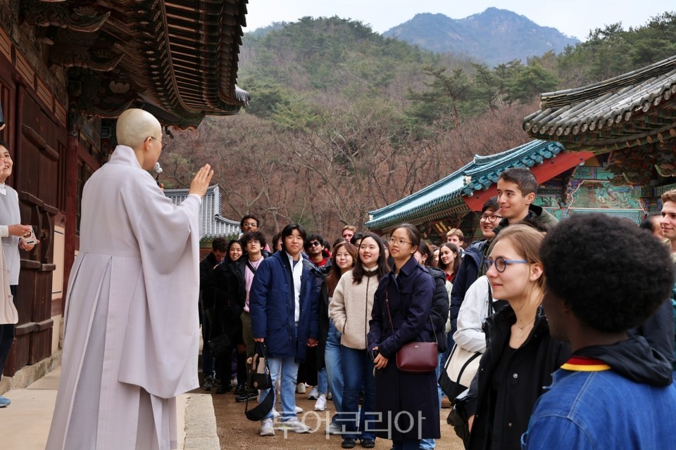 하버드 학생들이 진관사 대웅전 앞에서 불교에 관한 설명을 듣고 있다./사진-한국관광공사